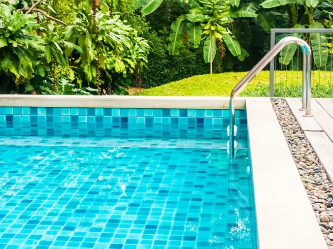 Blue tiled pool corner with steel ladder