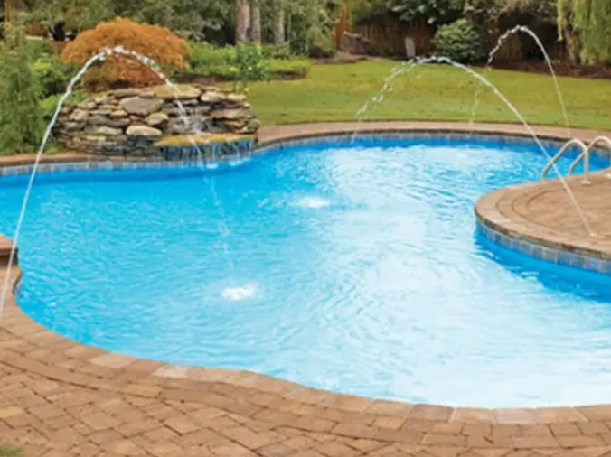 Curved pool with fountain sprinklers